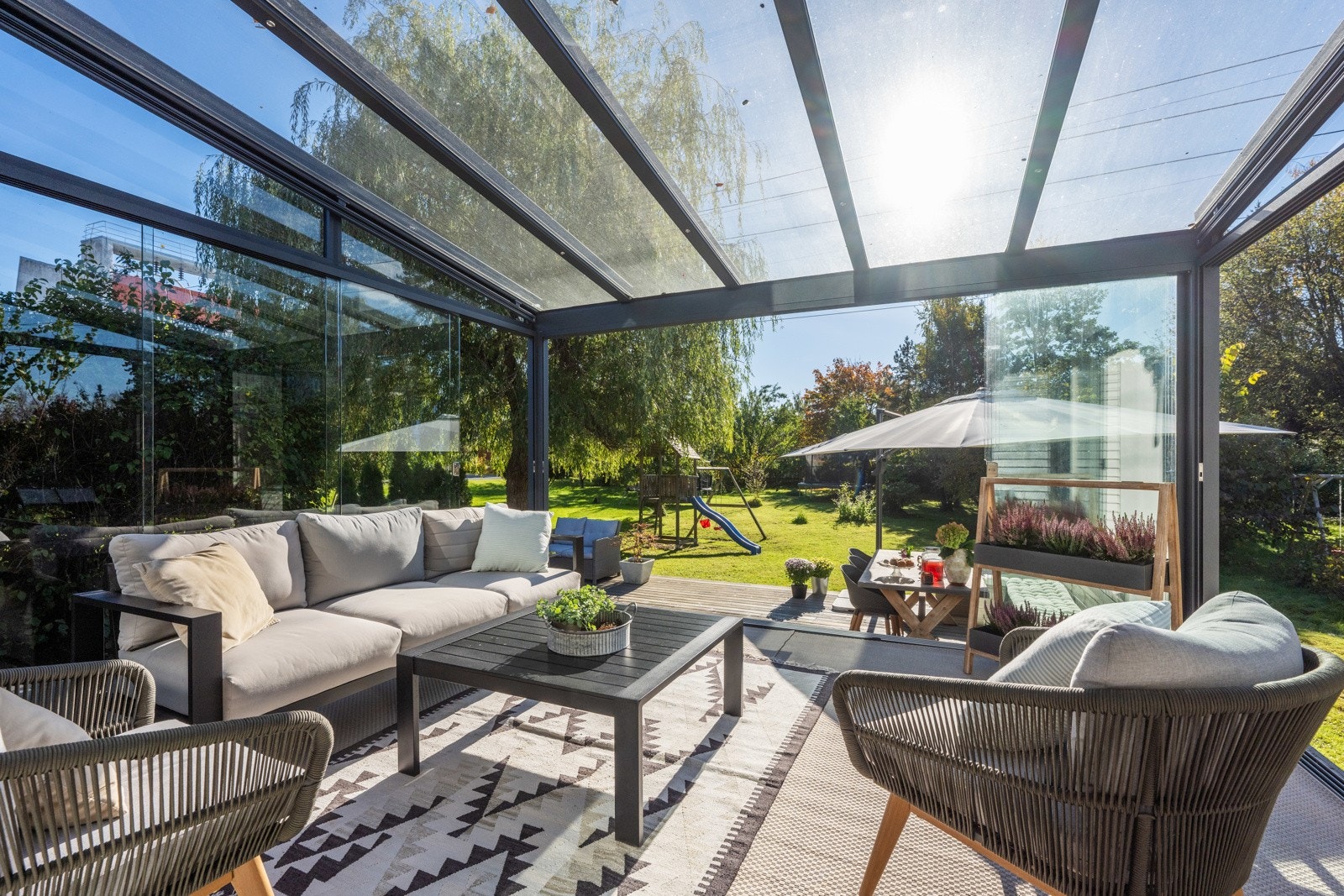 Nydelig uteområde med stor terrasse og utestue i glass Galleribilde