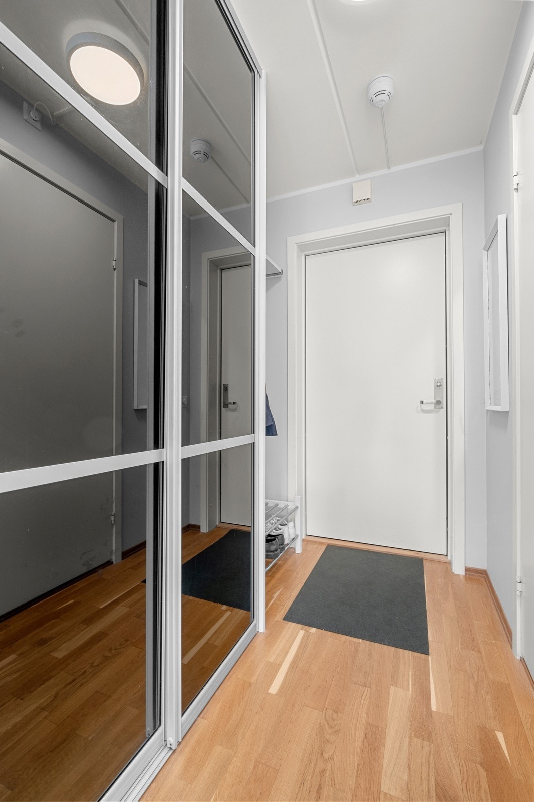 Romslig og praktisk entrè med skyvedørsgarderobe Galleribilde