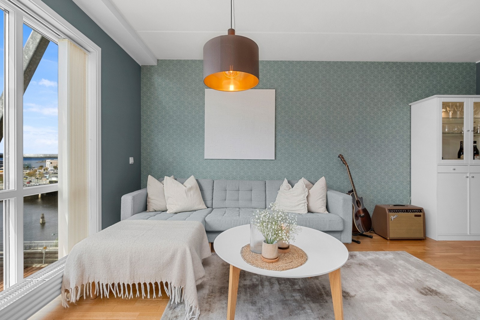 Lys og pen stue med store vindusflater som gir en god romfølelse Galleribilde