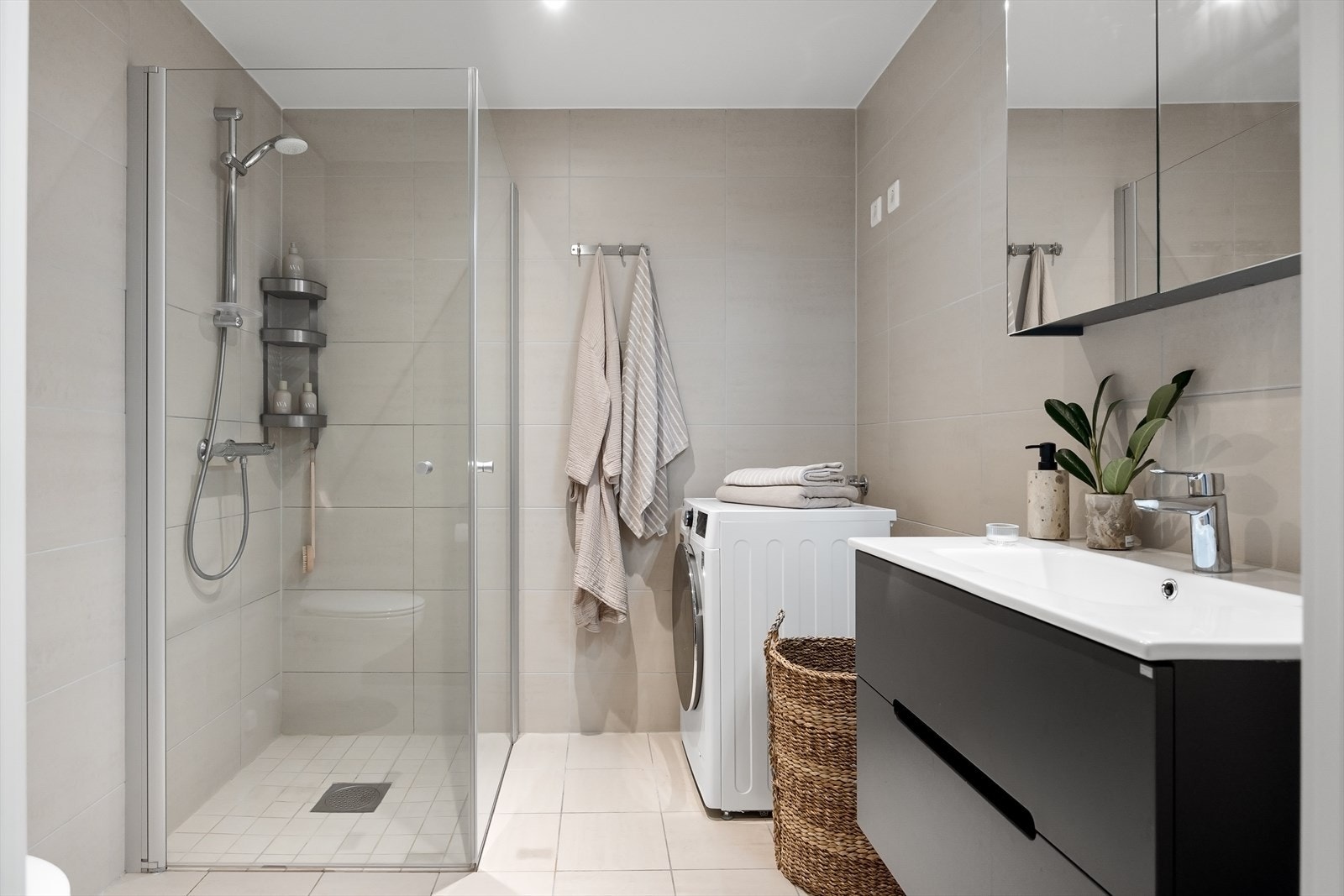 Badet er moderne og stilfullt, med beige fliser på veggene, downlights i taket, og hvite fliser på gulvet med behagelig gulvvarme! Galleribilde