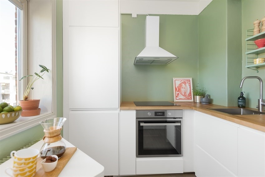 Rikelig med skap- og benkeplass kjøkkeninnredning fra IKEA med hvite fronter og eik benkeplate. Galleribilde