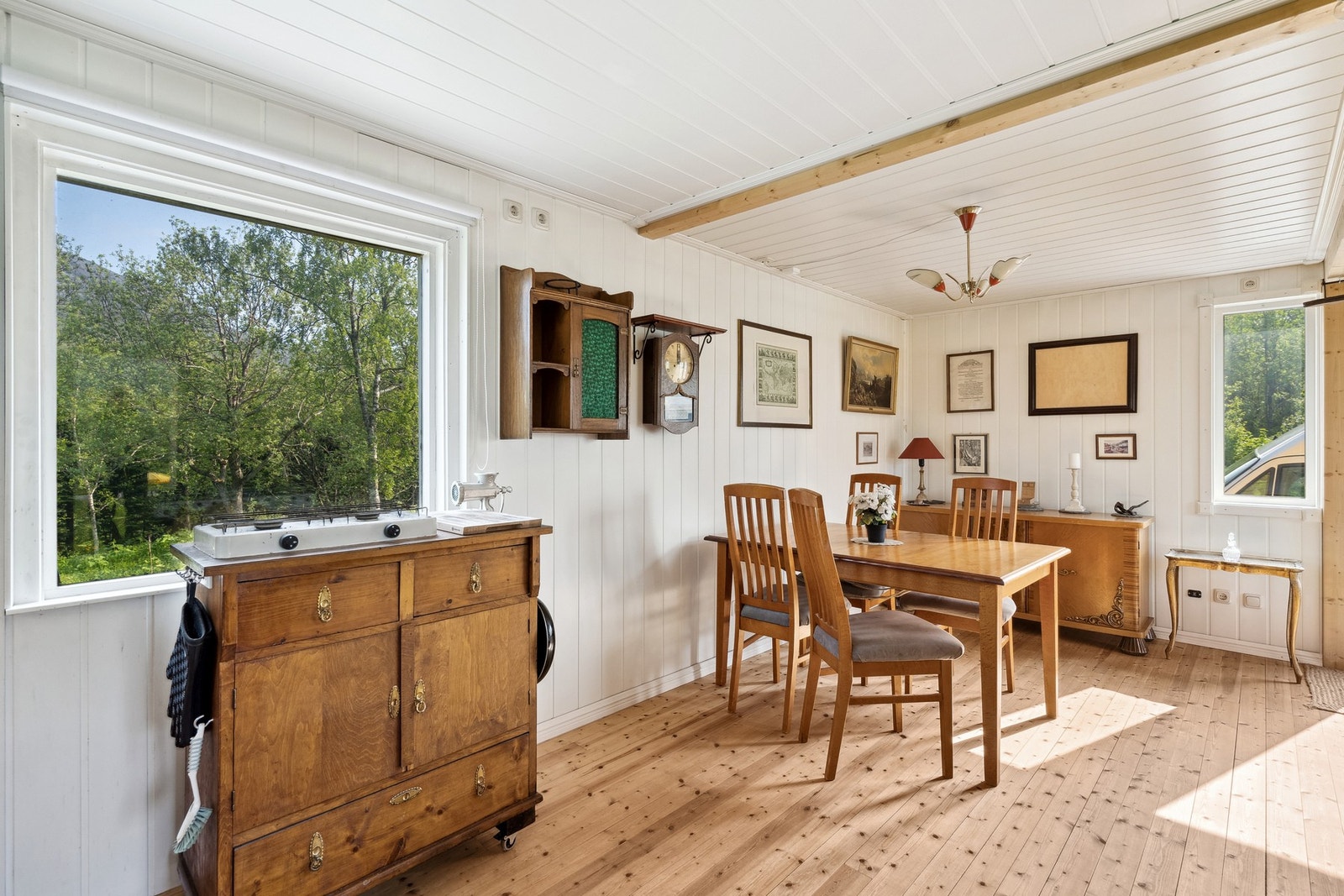 Oppholdsrommet er innredet med blant annet spisebord og en mindre sittegruppe i enden. Koselig vedovn etablert sentralt i rommet. Galleribilde