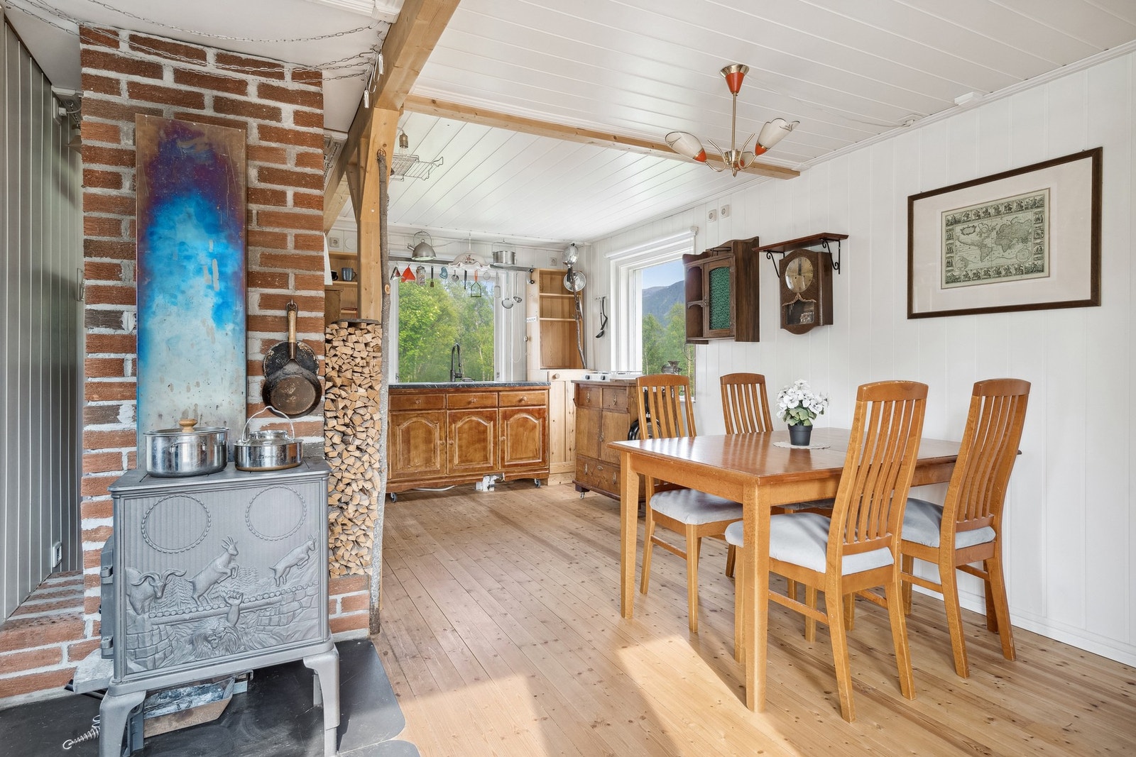 Oppholdsrommet er innredet med blant annet spisebord og en mindre sittegruppe i enden. Koselig vedovn etablert sentralt i rommet. Galleribilde