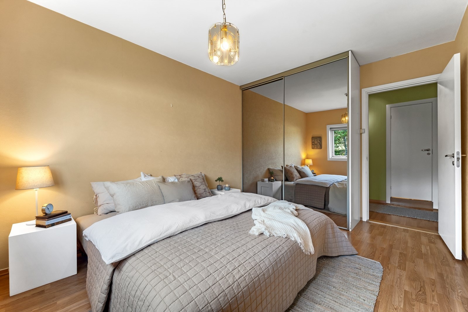 Soverom 1 med laminat på gulv, tapet på vegger og malt tak. Rommet har montert en stor og praktisk speil skyvedørsgarderobe. Galleribilde