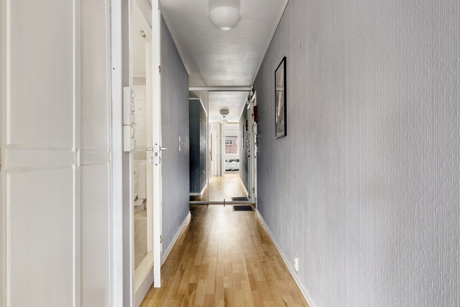 Romslig gang med oppbevaringsplass og lyse overflater med pent parkettgulv. Galleribilde