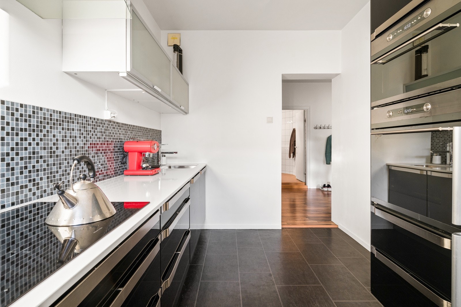 Integrerte hvitevarer: platetopp, opphøyd komfyr, mikrobølgeovn og oppvaskmaskin, samt frittstående kjøle- og fryseskap. Galleribilde