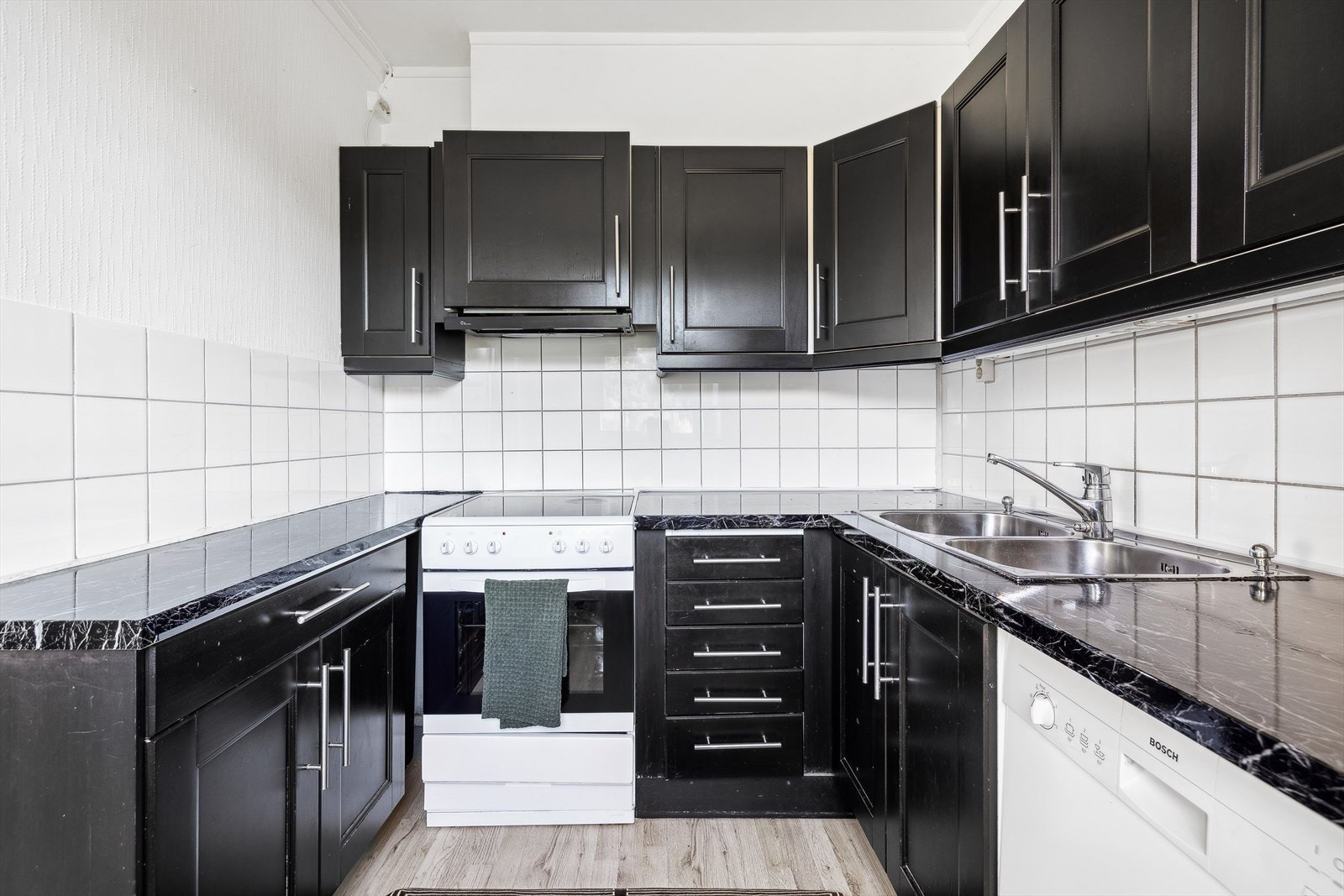 Kjøkkeninnredning med profilerte, fabrikklakkerte fronter og laminat benkeplate. Galleribilde
