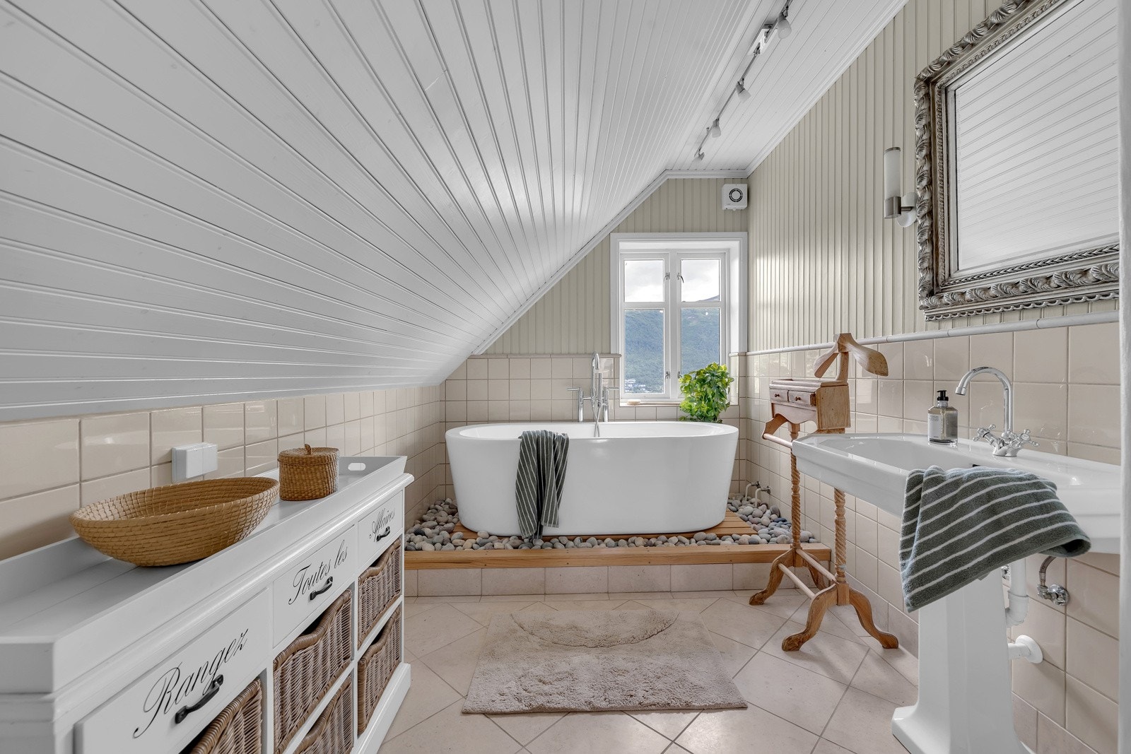 Badet i denne etasjen er virkelig lekkert. Her finner du flotte detaljer som oppbygget badekar omkranset av rullestein og inventar som er skreddersydd stilen Galleribilde