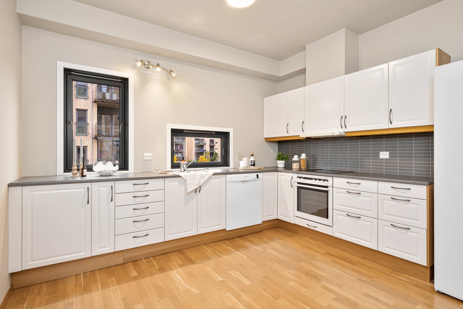 Innenfor stuen har leiligheten et luftig kjøkken med plass til spisebord for hyggelige frokoster og rolige morgenstunder Galleribilde