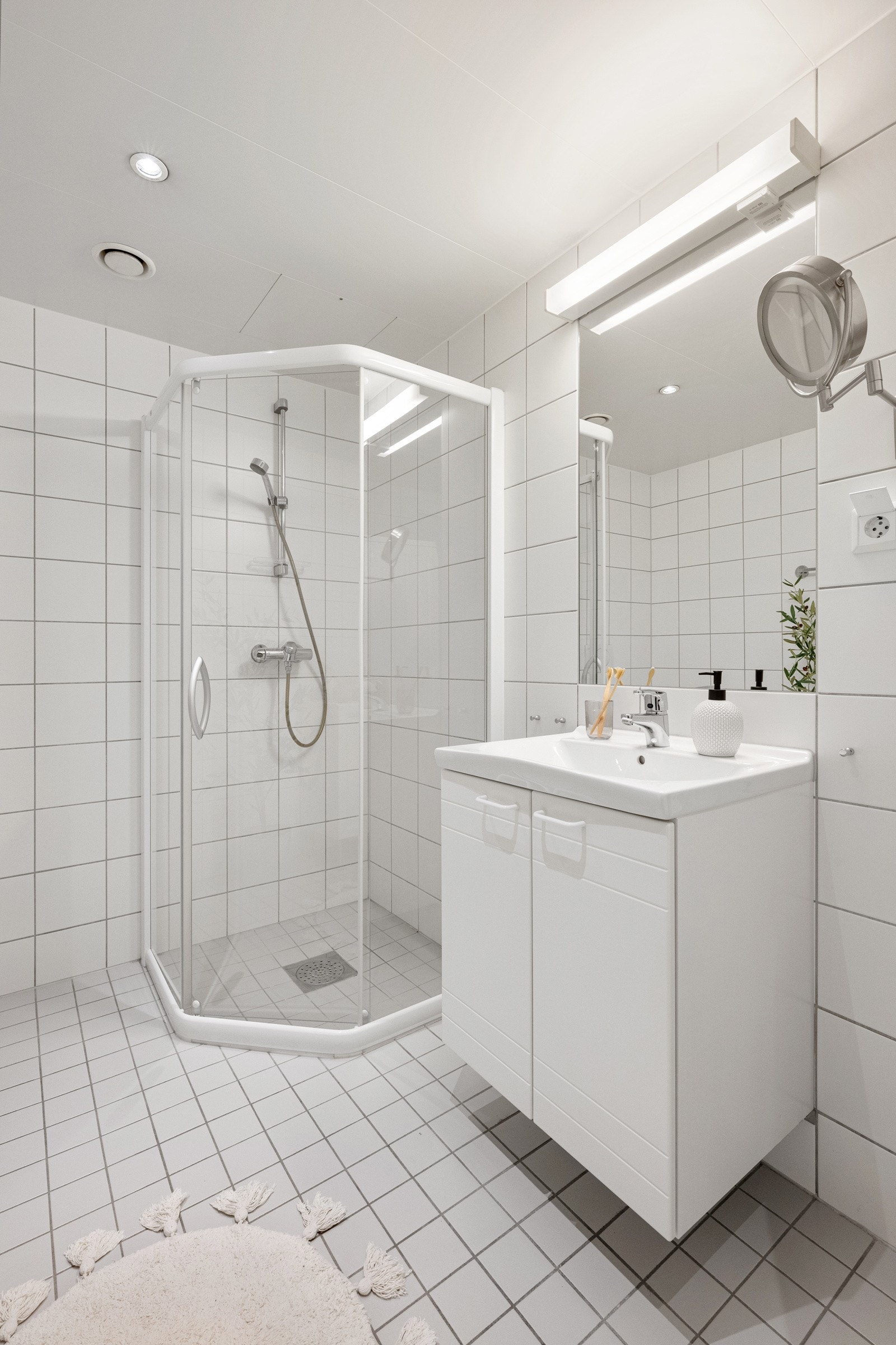 Den øvrige innredningen består av servant med hvite underskap, et hvitt benkeskap og et speil med belysning. Galleribilde