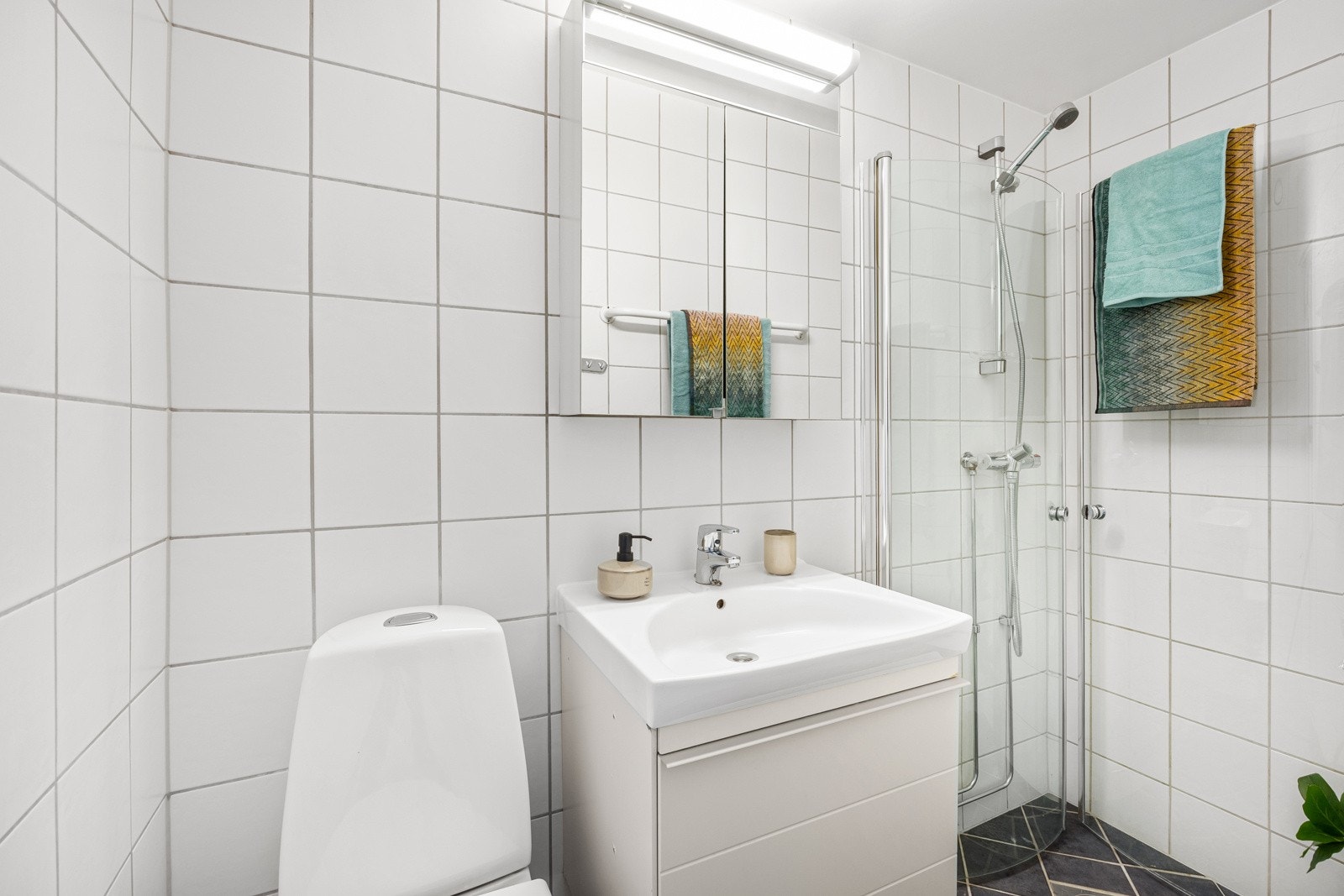 Badet, som er fra 2007, er praktisk innredet med dusjhjørne, servantskap (litt slitt) og speilskap med lys. Galleribilde