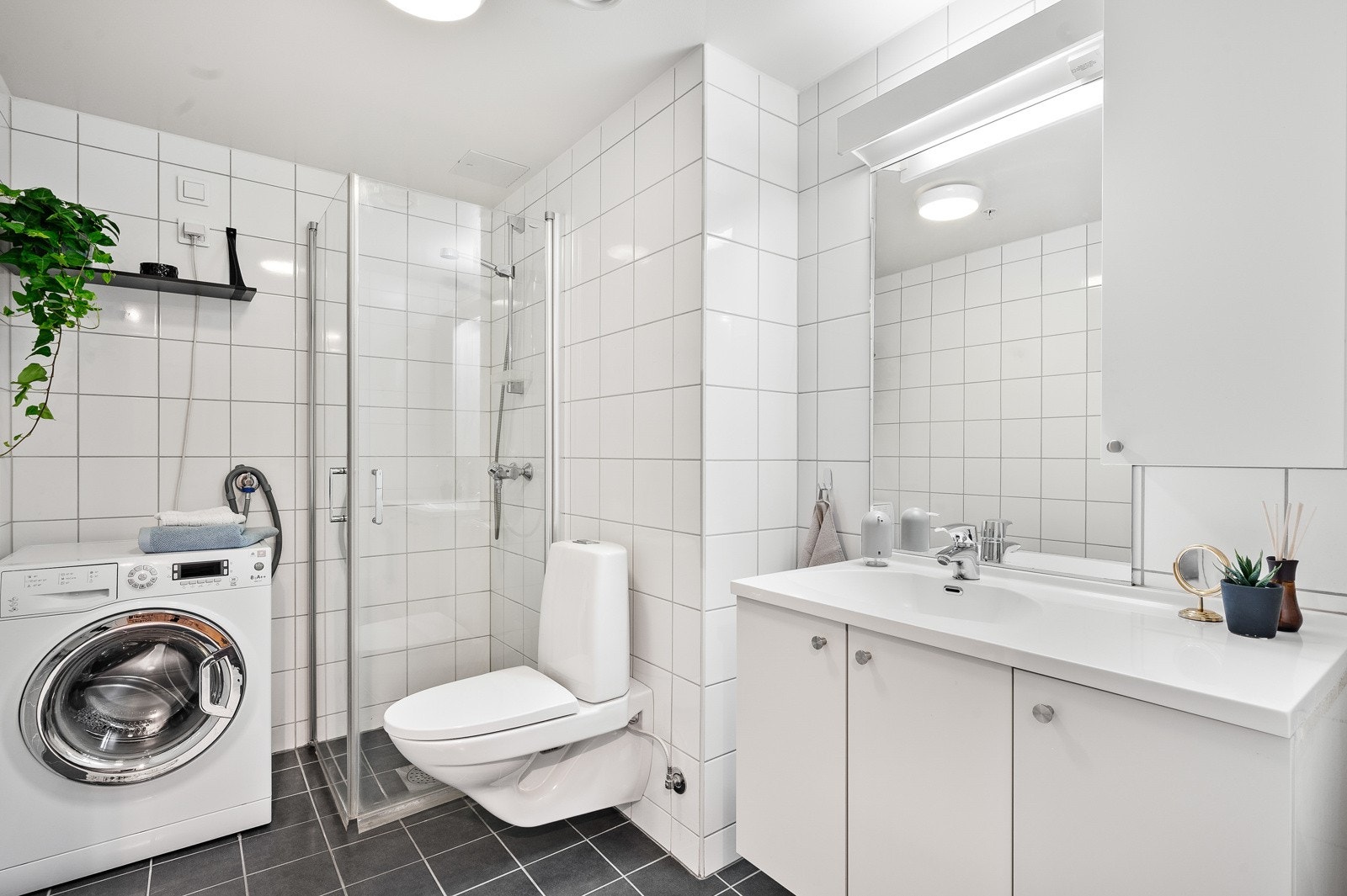 Stort og fint baderom av god standard med flislagte overflater og varmekabler i gulv. I tillegg er det opplegg for vaskemaskin og plass til tørketrommel. Galleribilde