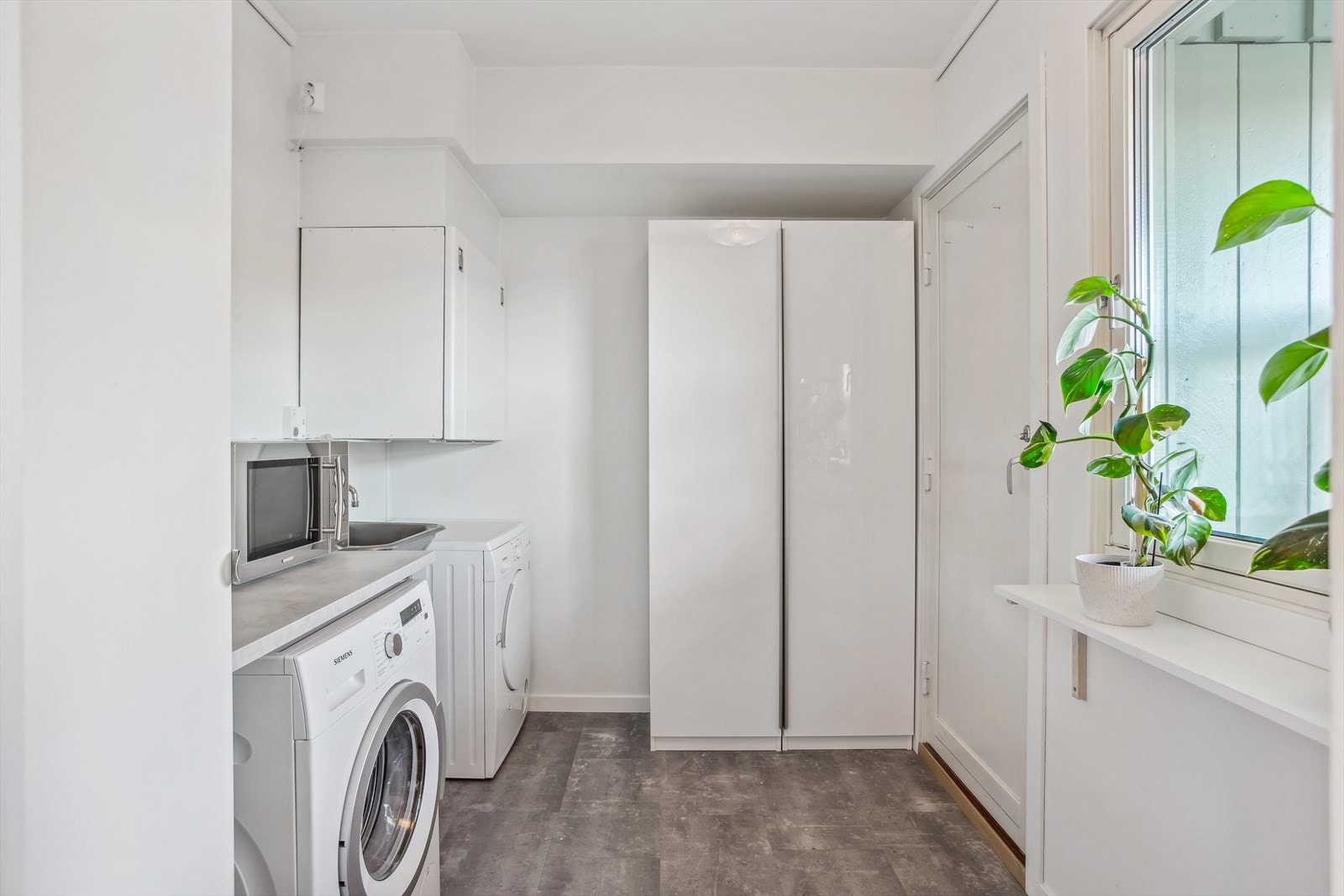 Teknisk rom/ vaskerom som er utstyrt med motorskapet for balansert ventilasjon, rør-i-rør skap for vanntilførsel og opplegg for vaskemaskin. Fra teknisk rom/ vaskerom er det dør ut til bod. I bod har eier plassert fryseboksen sin Galleribilde