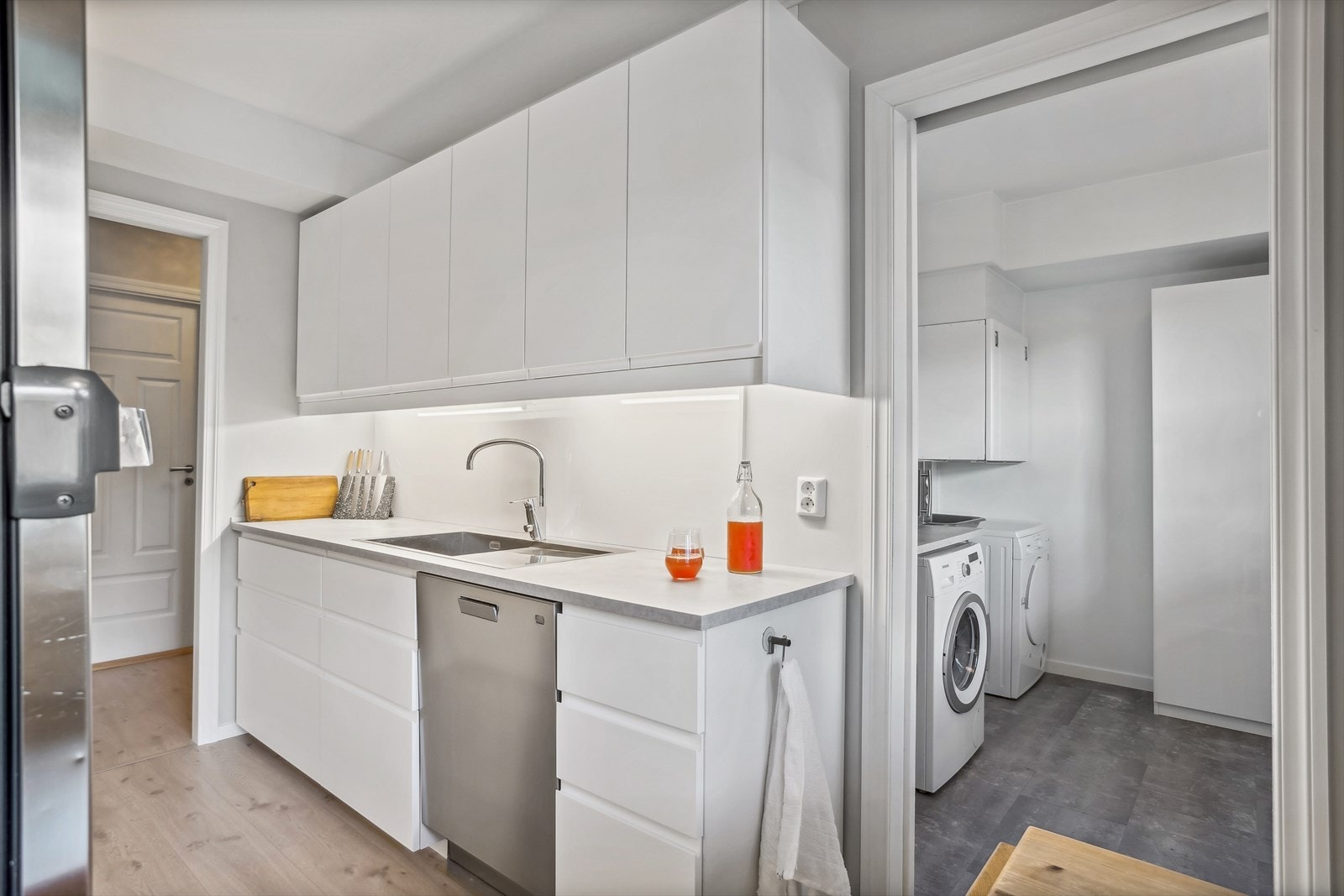 Kjøkkenet er utstyrt med komfyr, kjøleskap, oppvaskmaskin og kjøkkenventilator. Fra kjøkkenet er det inngang til et teknisk rom/ vaskerom Galleribilde