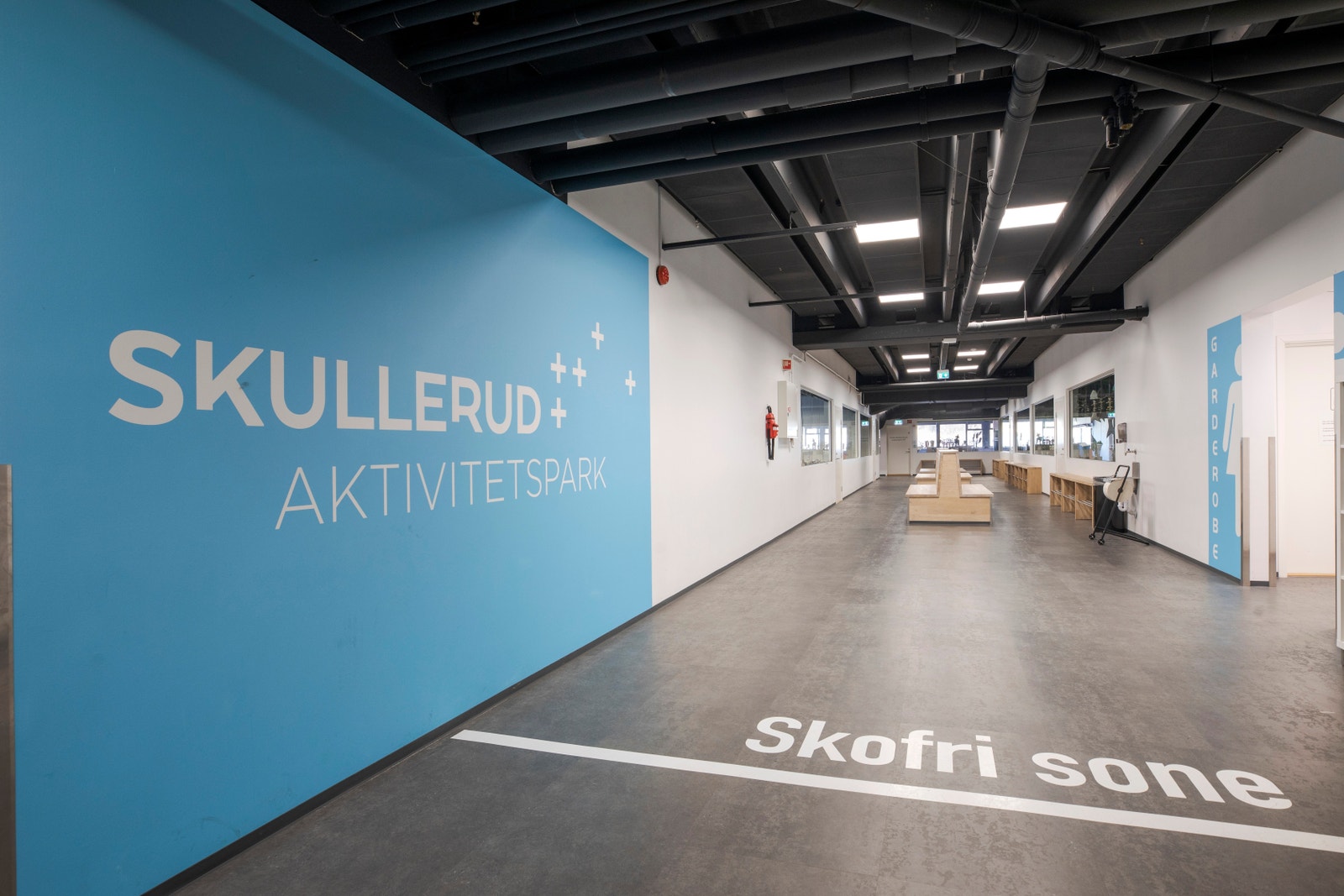 Romslig inngangsparti med mange sitteplasser og garderober. Galleribilde