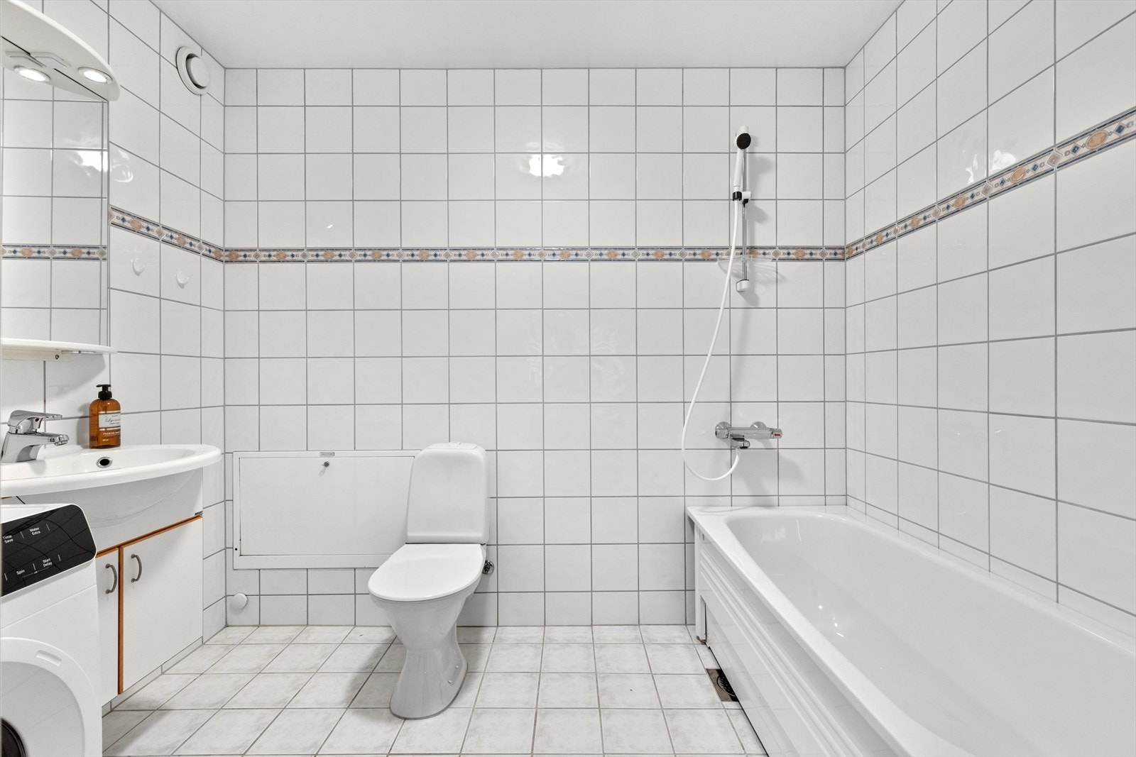 Bad i tilknytning til hovedsoverom - Badet har benkeskap med glatte fronter og speil med belysning over servant Galleribilde