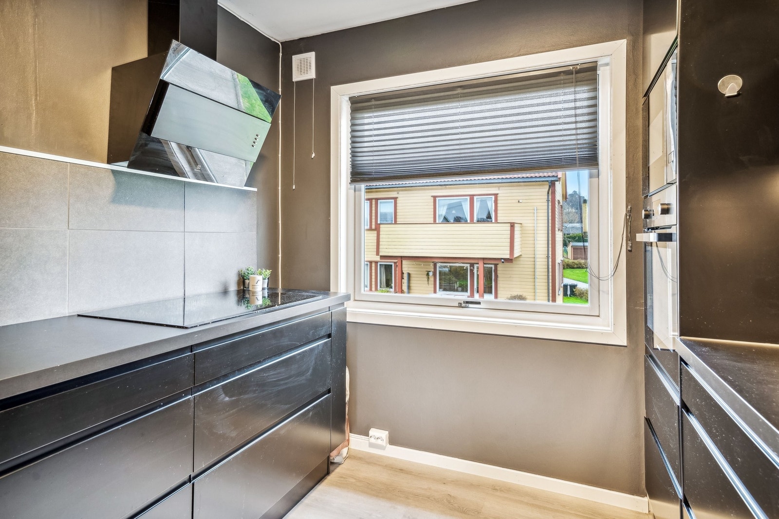 Moderne kjøkken med svarte fronter og stilrene, integrerte hvitevarer – designet for funksjon og eleganse. Galleribilde