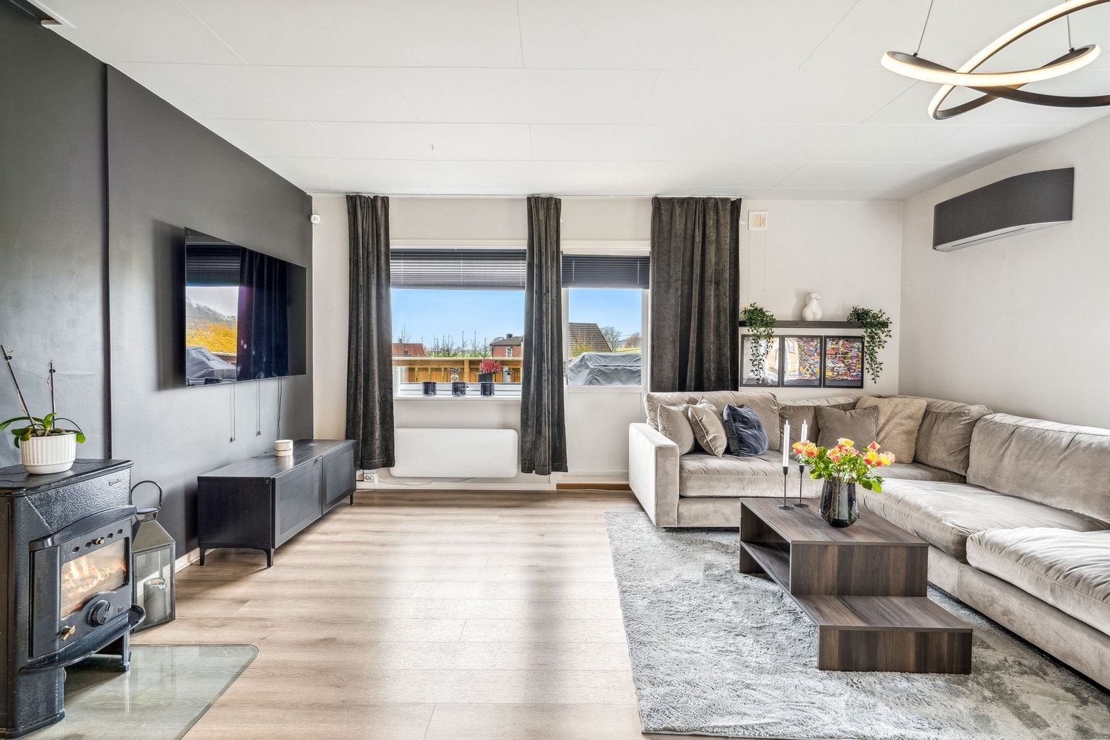 Romslig stue med moderne varmepumpe installert i 2024 og vedovn som gir ekstra varme og hygge Galleribilde