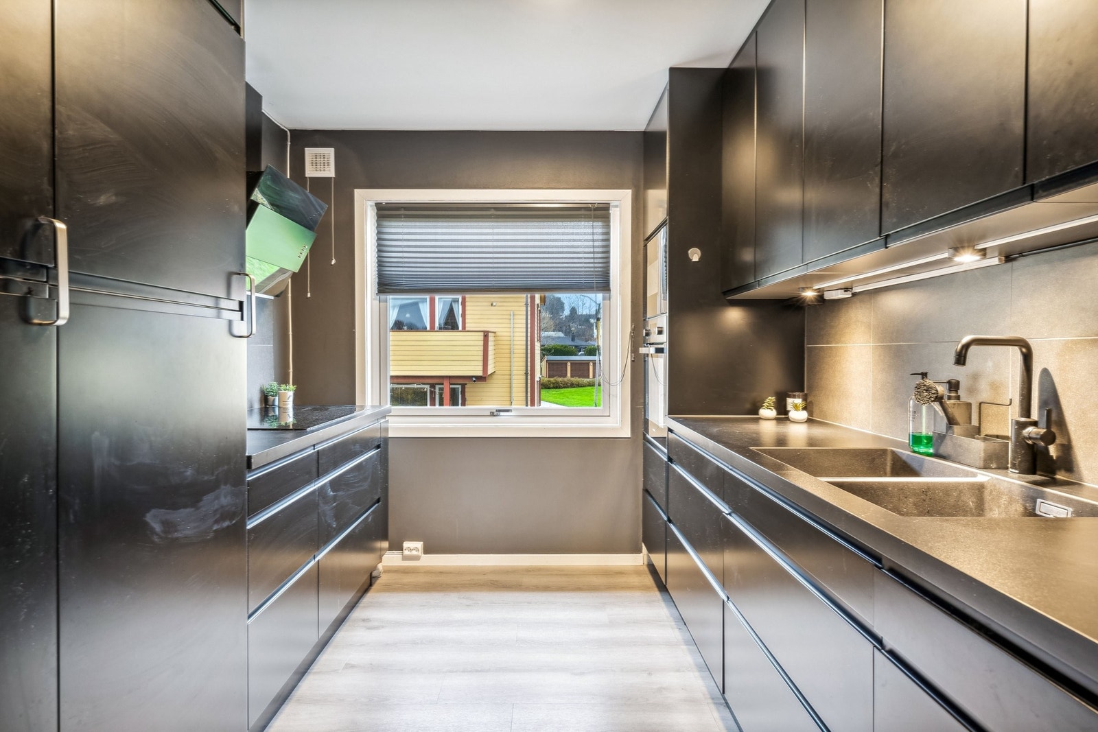 Moderne kjøkken med svarte fronter og stilrene, integrerte hvitevarer – designet for funksjon og eleganse. Galleribilde