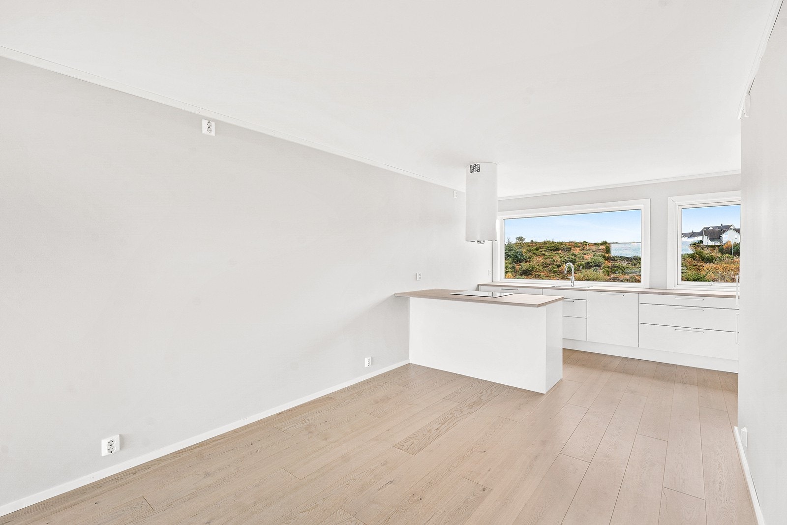 Kjøkkenet har kjøkkenøy med steketopp og takvifte samt god arbeidsplass foran de store vinduene med gode lysforhold. Galleribilde