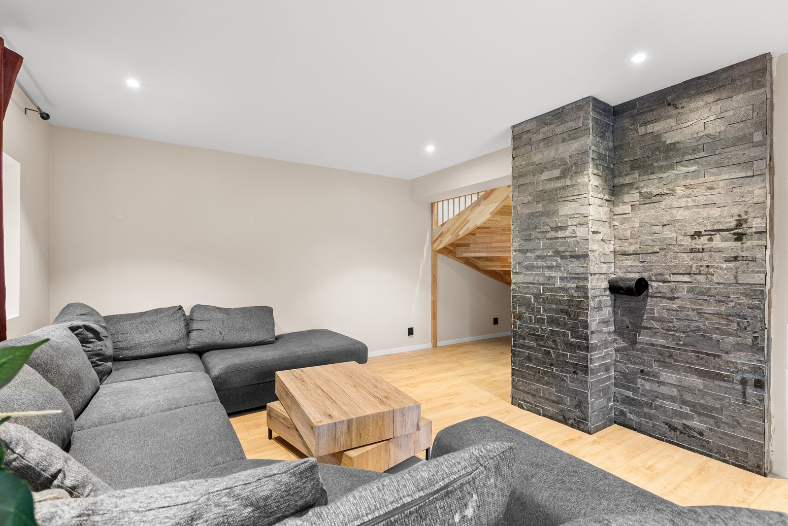 Stue med stilige natursteinsvegger og spotbelysning i taket. Pipeløp som gir mulighet til å sette inn en peis med enkle grep. Galleribilde