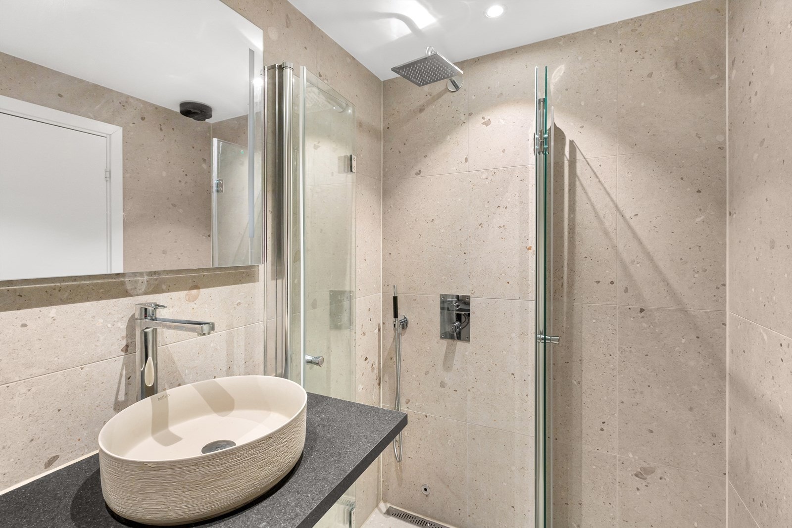 Komfortabelt bad med elegant servant og dusjhjørne med regndusj. Galleribilde