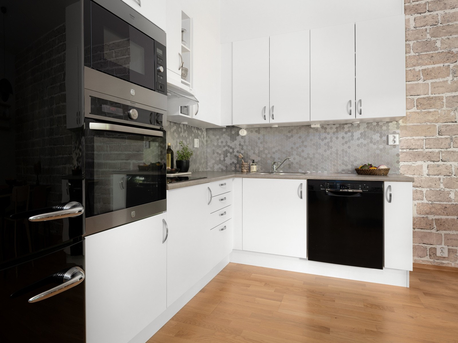 Hvitevarer som frittstående kjøleskap med fryser og oppvaskmaskin, integrert stekeovn, mikrobølgeovn og nedsenket induksjonstopp medfølger salget. Galleribilde