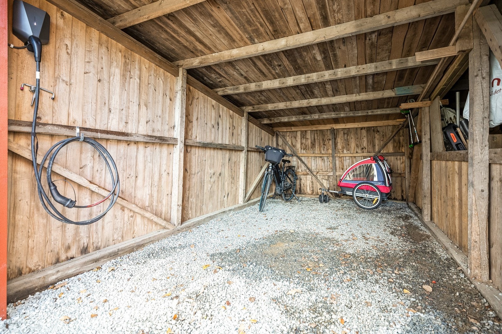 Leiligheten disponerer en garasjeplass i rekke som er gjort om til carport. Det er montert Easee el-billader i carporten. Galleribilde