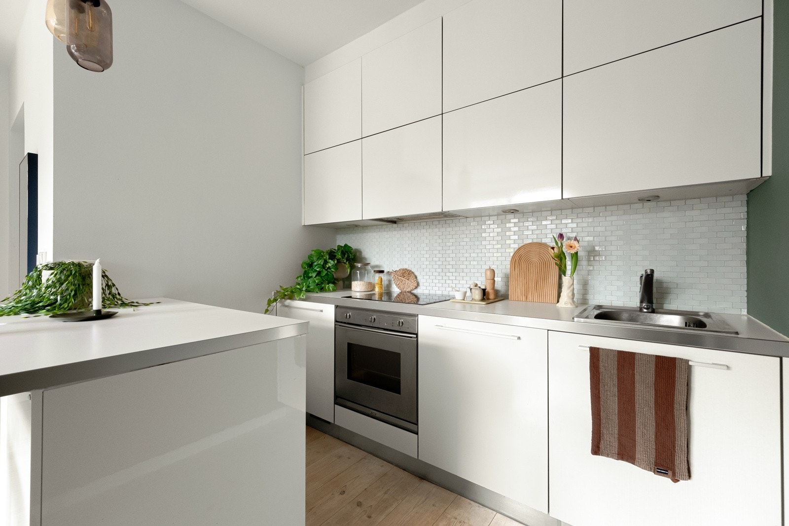 Slett og delikat kjøkkeninnredning med skap helt opp til taket, som gir godt med oppbevaring. Galleribilde