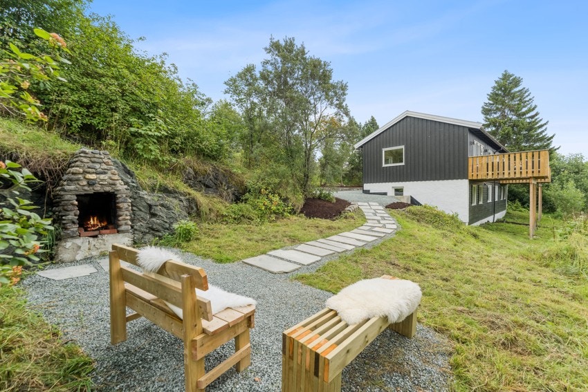 Boligen har en steinbelagt sti til et hyggelig uteområde med benker og utepeis. Galleribilde