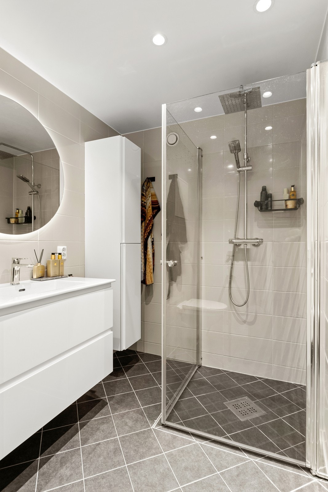 Det er varmekabler i gulvet og rommet har innredning med servant, veggmontert toalett og dusjhjørne Galleribilde