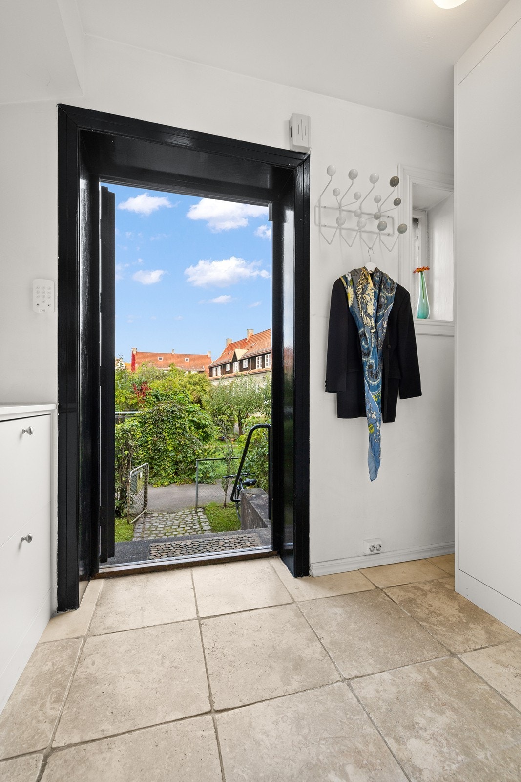 Flislagt entré med varmekabler og plassbygde hyller og skap til oppbevaring Galleribilde