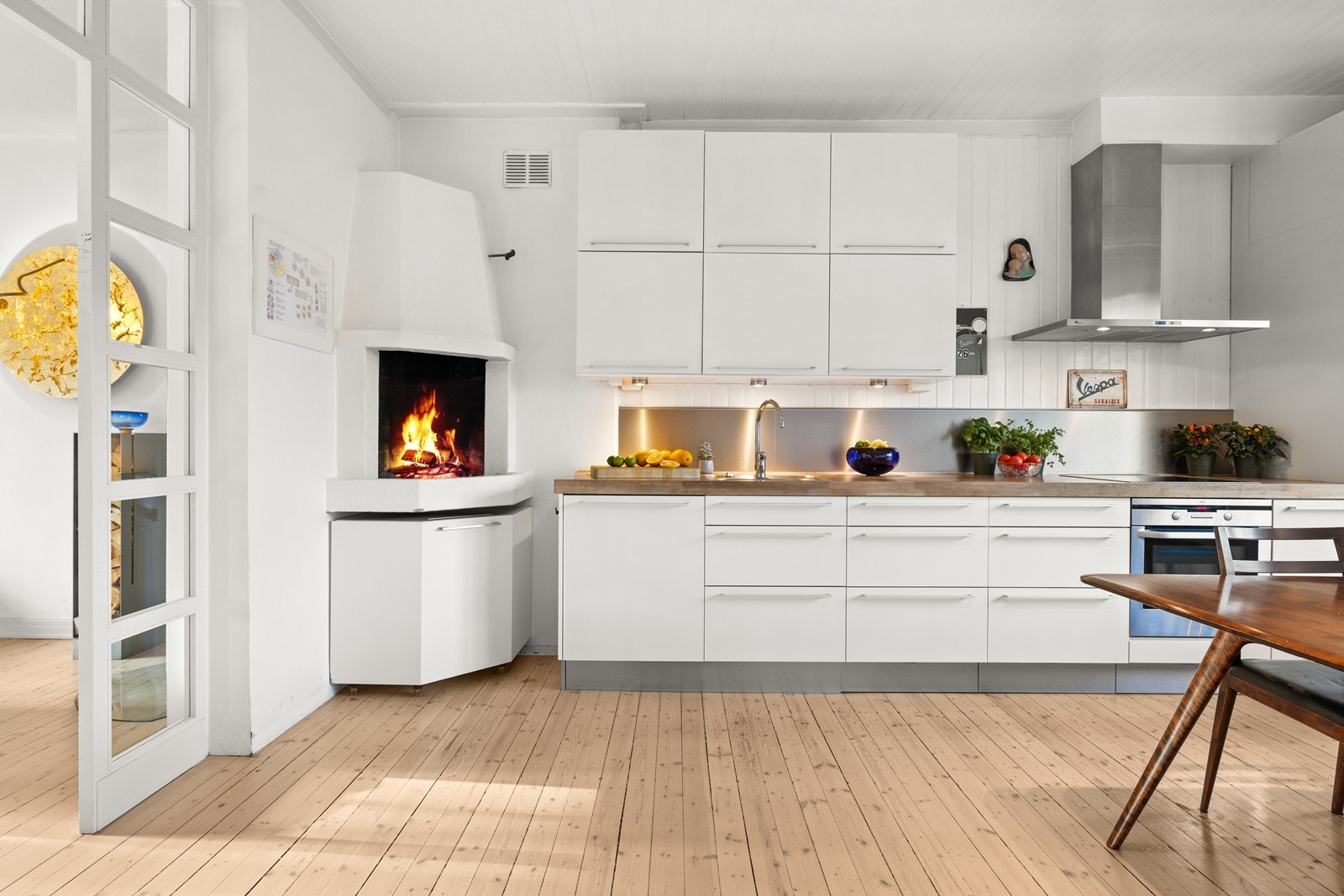 Kjøkkenet har flott åpen peis, HTH innredning med heltre benkeplate og integrerte hvitevarer Galleribilde