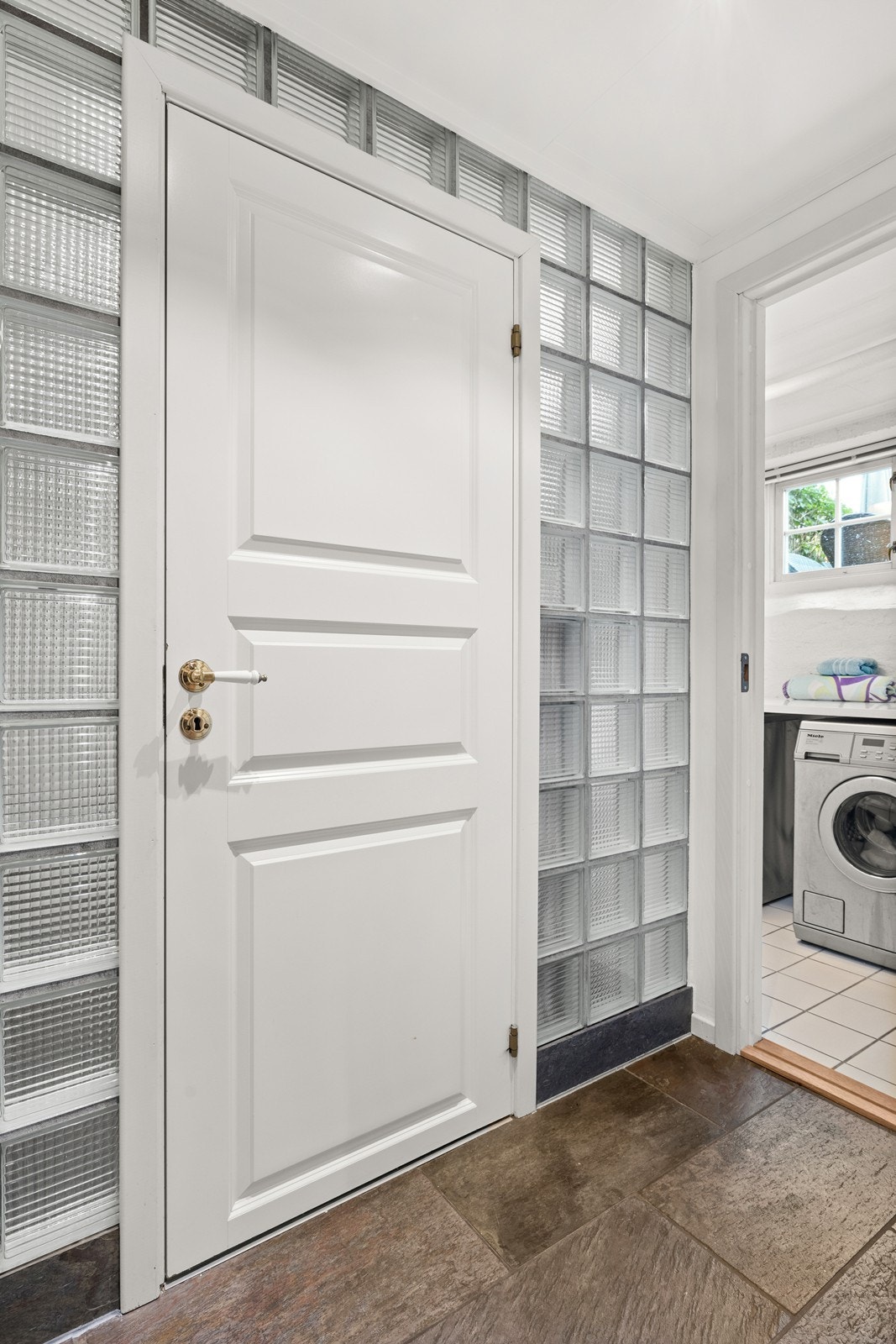 Her ser vi en mellomgang med dør rett frem til badet, til venstre er det en bod og til høyre er vaskerommet Galleribilde