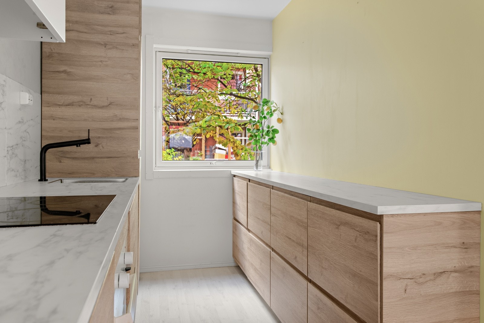 Innredningen har hvite, glatte skapfronter og benkeplate av laminat. Galleribilde