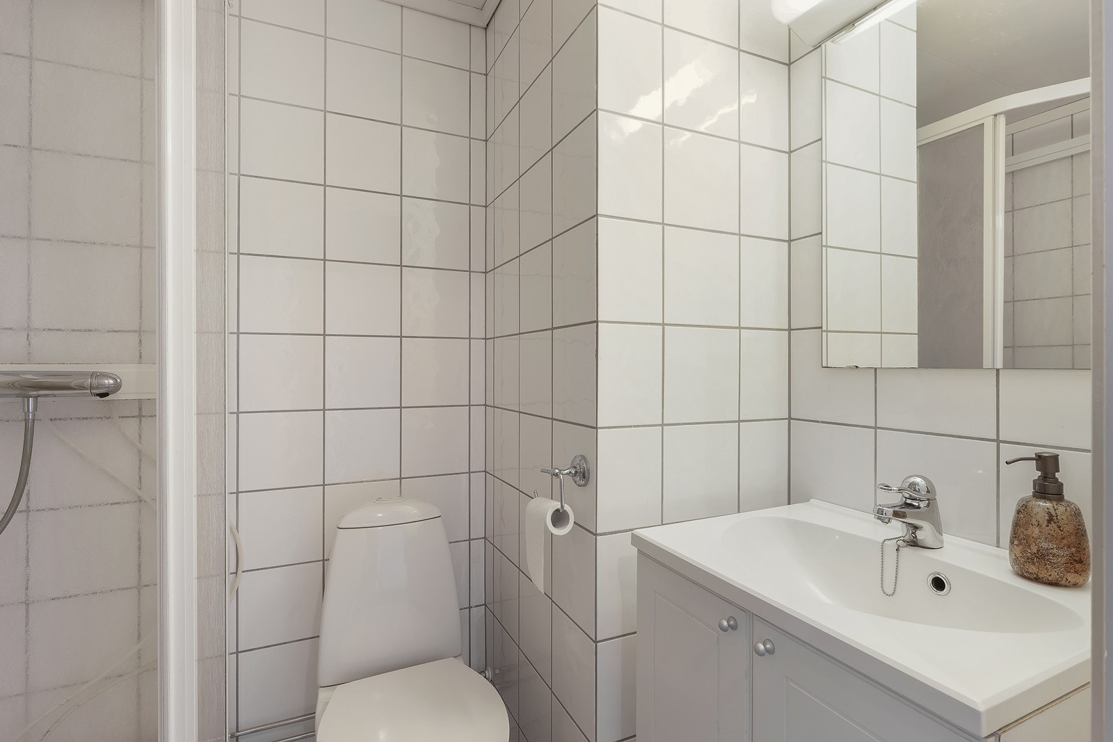 Inneholder toalett, dusjkabinett og vask med innredning. Galleribilde