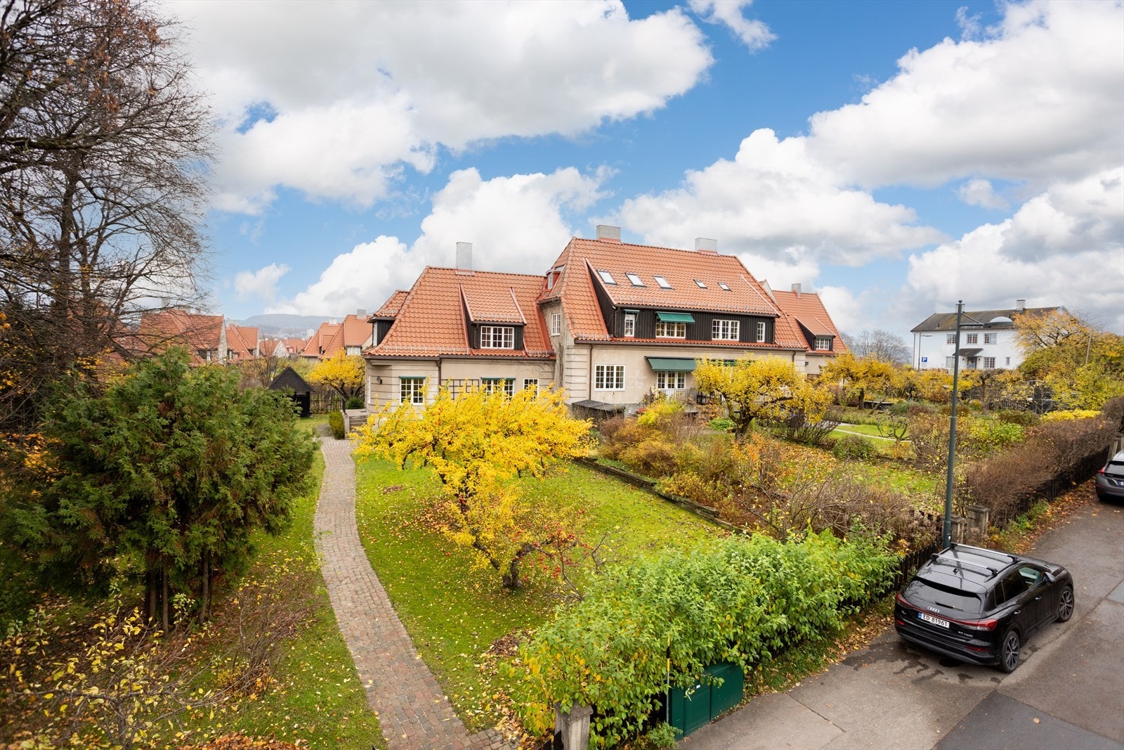 Huset sett fra Tiurveien. Eiendommen grenser også mot Minneparken som ligger til venstre på bildet og liten felles lekeplass bak huset. Galleribilde