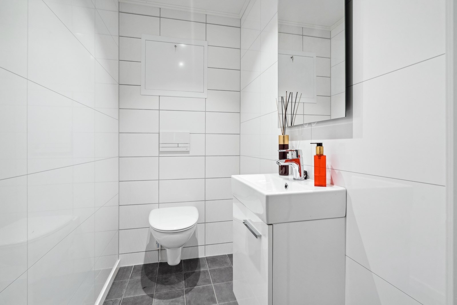 Nytt pent wc rom med vegghengt klosett og servantskap. Galleribilde