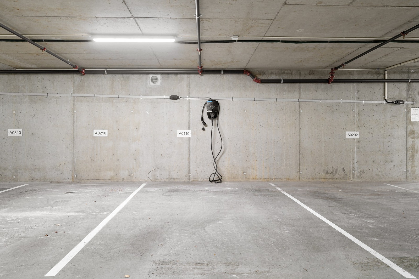 Parkeringsplass med elbillader i oppvarmet kjeller. Galleribilde