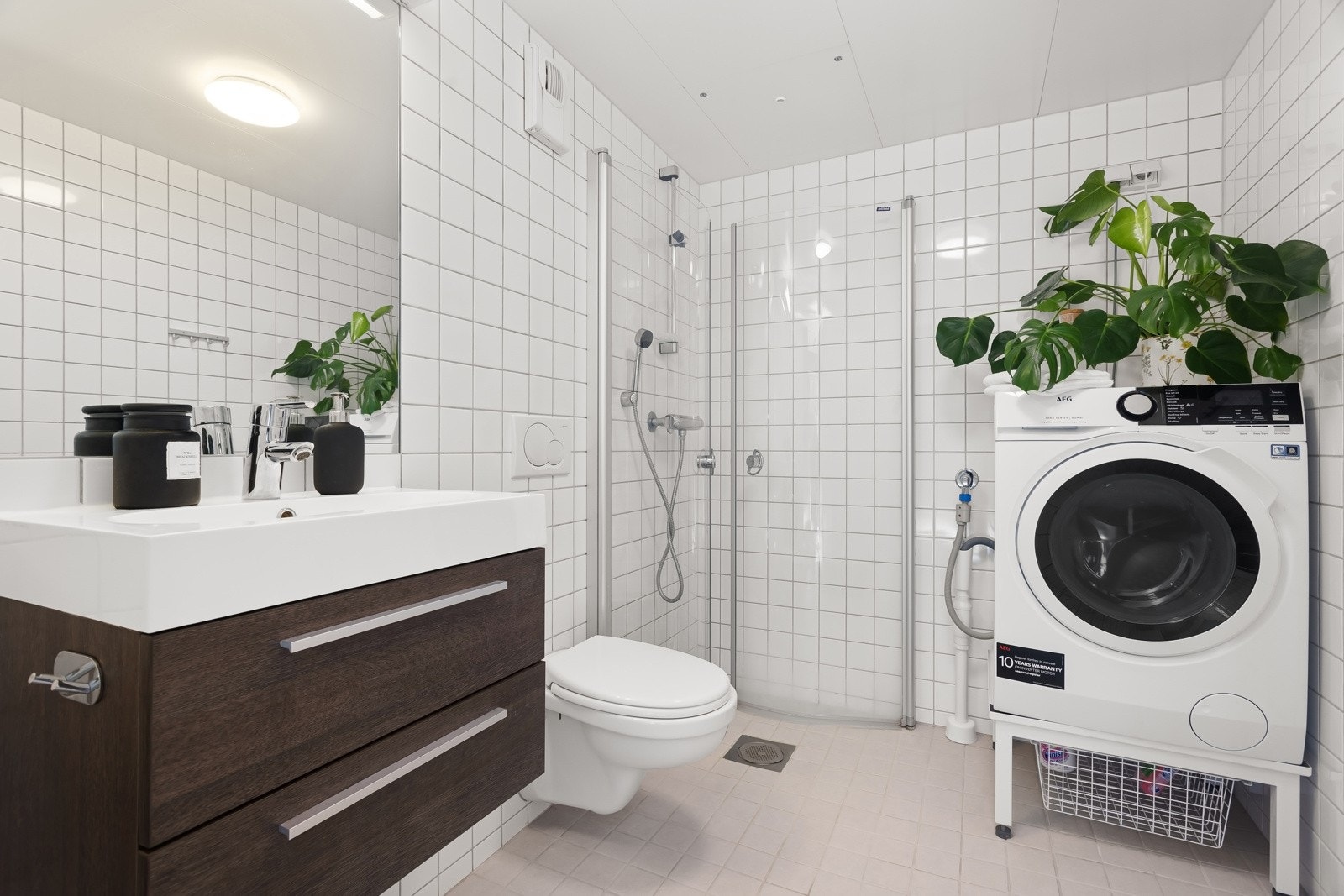 Flislagt bad med varmekabler i gulv og opplegg for vaskemaskin. Galleribilde