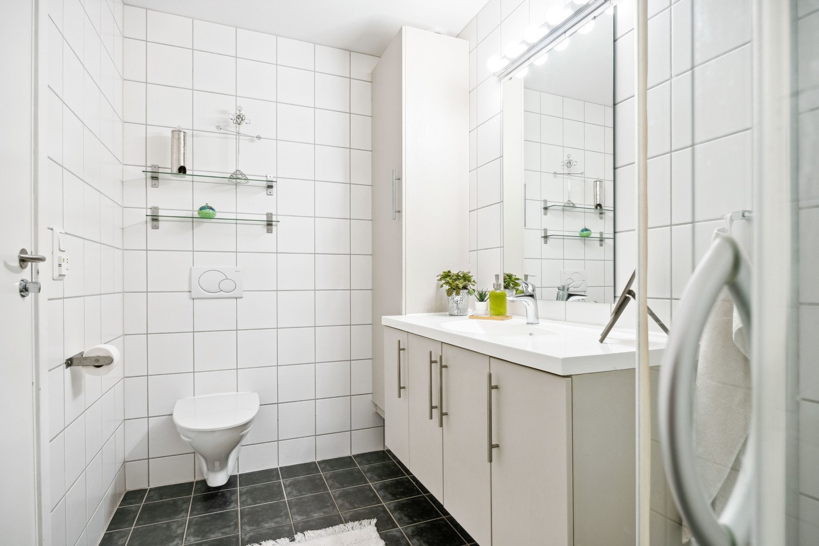 Badet er flislagt og utstyrt med dusjnisje, vegghengt toalett og gulvvarme. Galleribilde