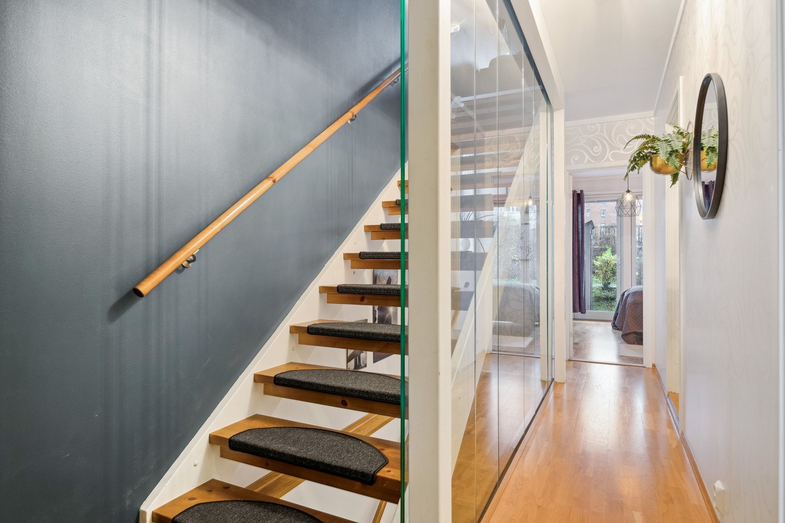 Fra entréen ankommer man et gangareal med adkomst til to soverom, baderom, samt trappeløp til øvrige etasjer. Trappen er utført med stilfull glassvegg som gir et moderne uttrykk som er gjennomgående i alle etasjer. Galleribilde
