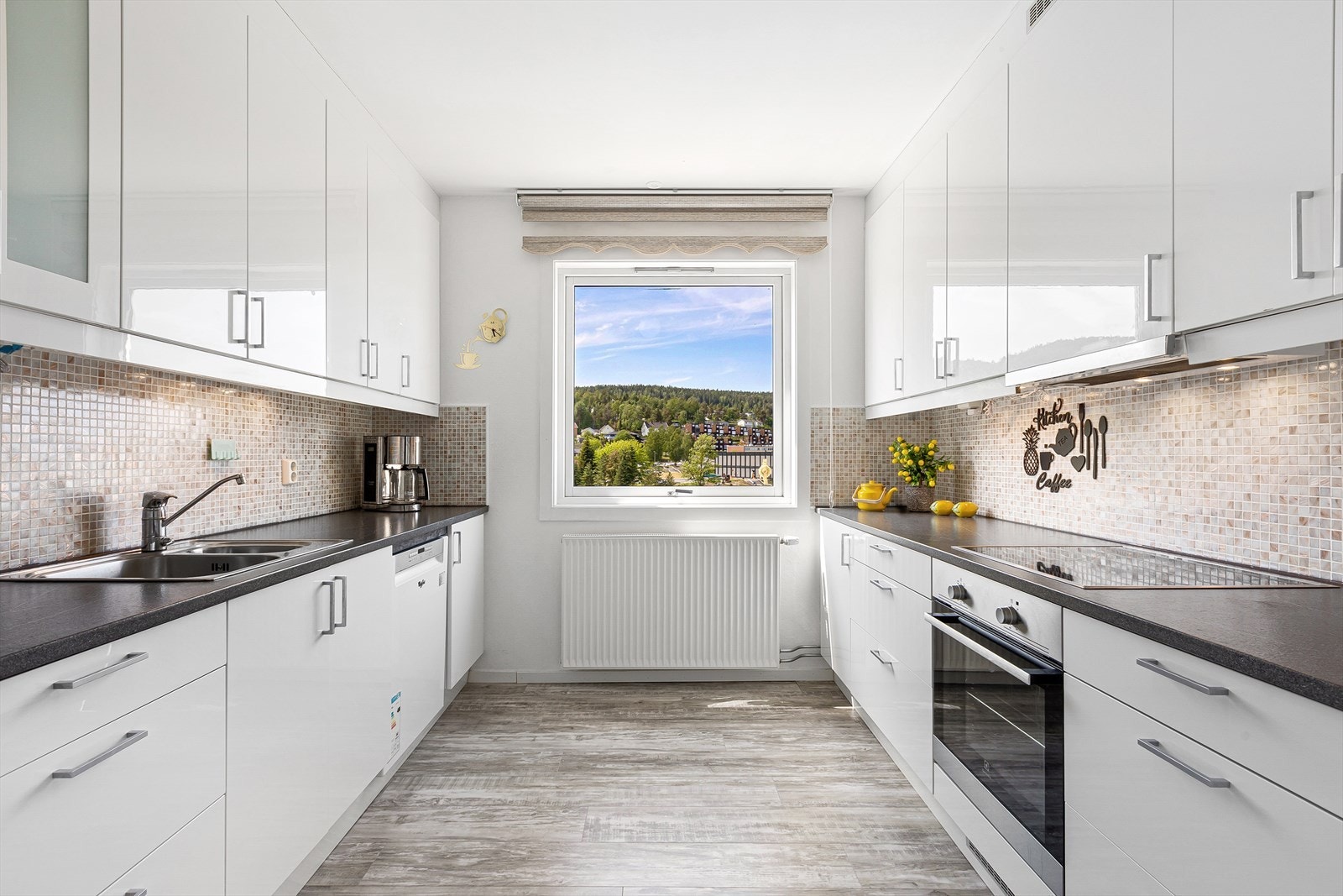 Lyst og pent Epoq kjøkken fra 2018, med fronter i høyglans og pene fliser over benk Galleribilde