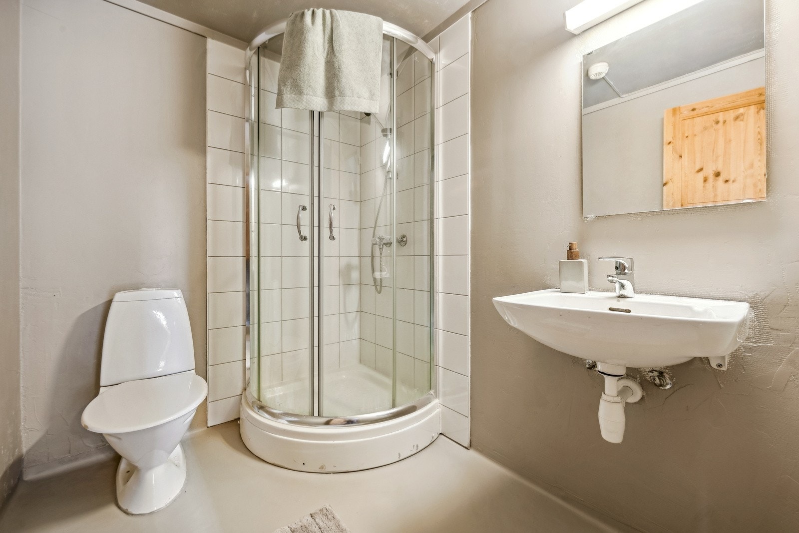 Gulvflate belagt med gulvbelegg med gulvvarme, baderomsbelegg, mikrosement og fliser på vegg. Galleribilde