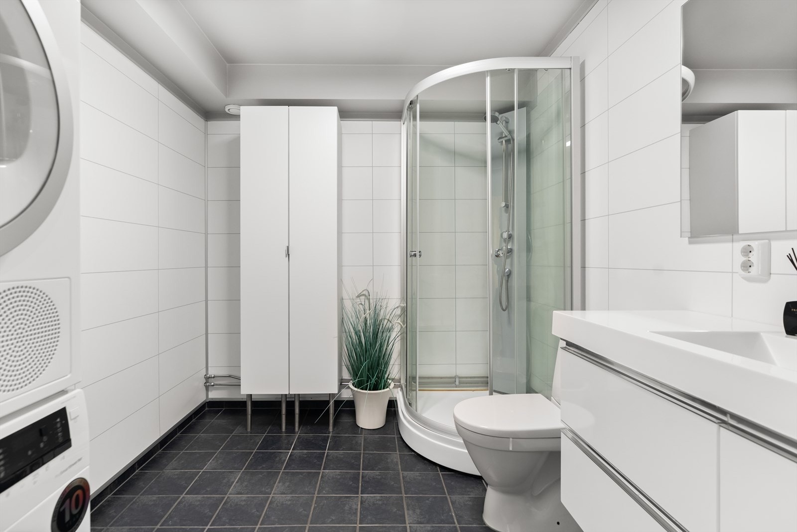 Romslig bad med god plass til både vaskemaskin og tørketrommel. Galleribilde