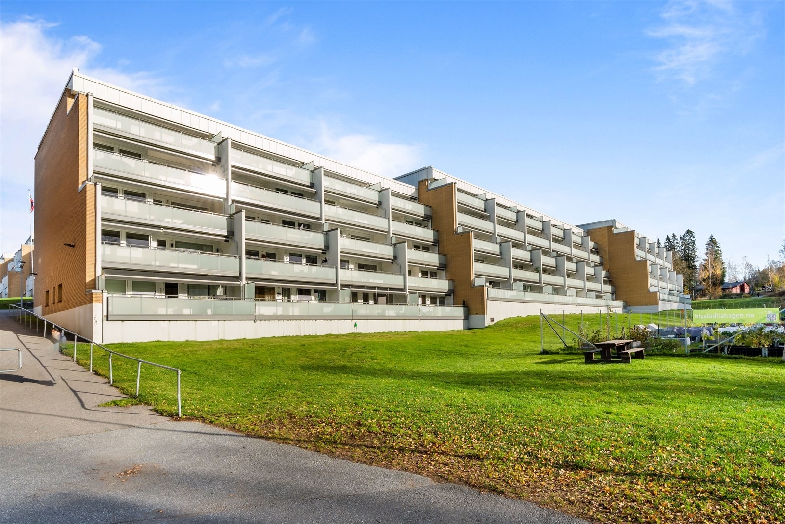 Solrik fasade med hyggelig grønt området rundt. Galleribilde