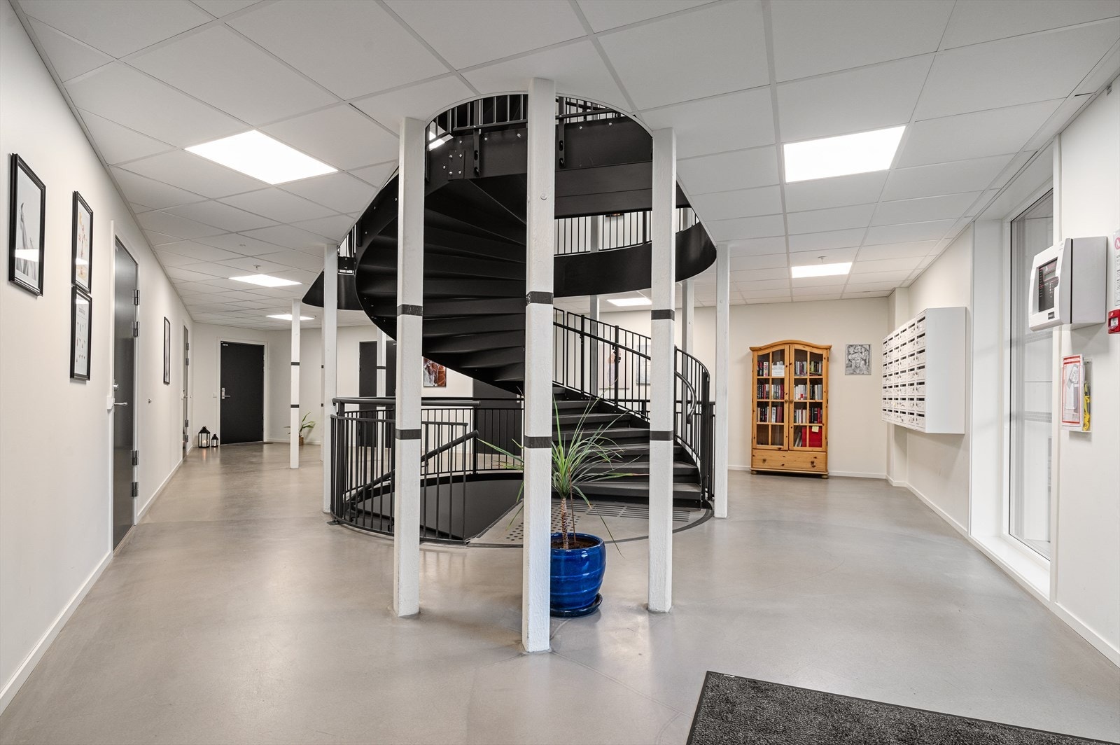 Adkomst til leilighetene via et stort innvendig fellesareal med heis/trappoppgang fra kjeller til øverste etasje. Galleribilde