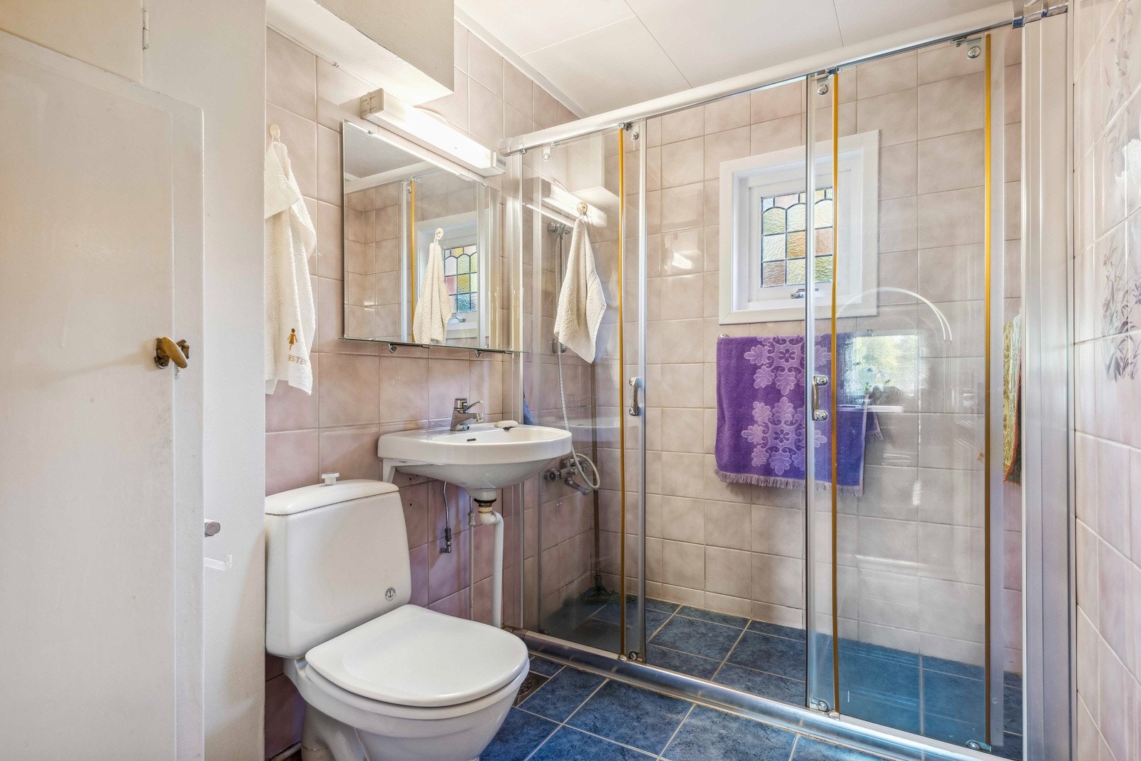 Romslig flislagt bad med varme i gulv og flislagte vegger samt veggflater av malte flater. Galleribilde