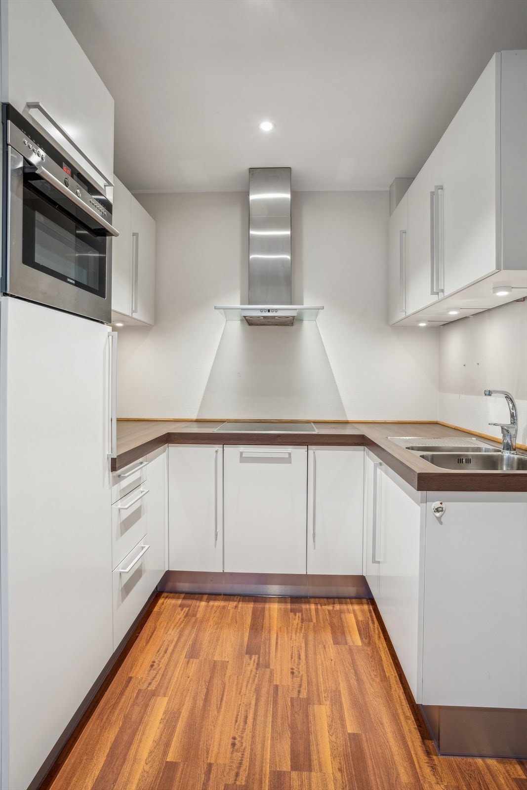 Innredningen har lyse glatte fronter, laminat benkeplate, nedfelt oppvaskkum, belysning under overskap og ventilator. Galleribilde