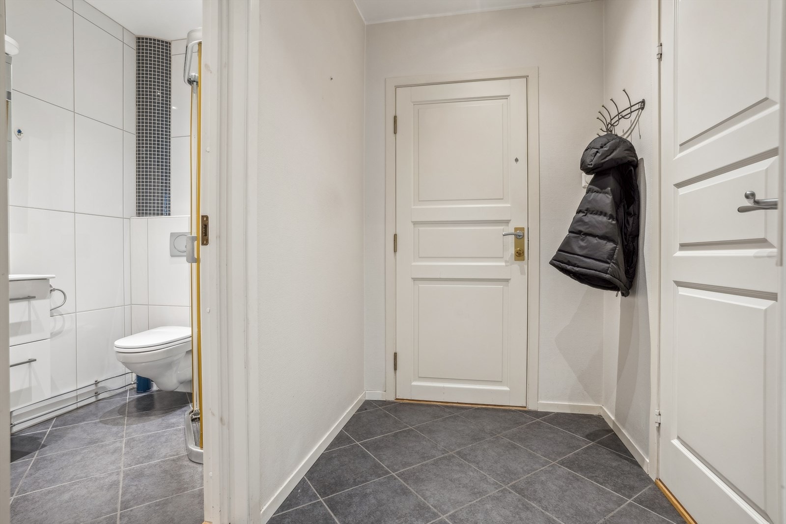 Leiligheten har en flislagt entré med plass til å henge fra seg yttertøy. Galleribilde